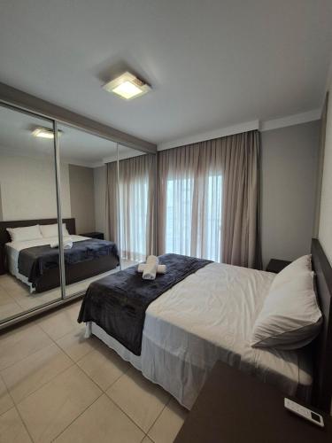 a bedroom with a bed and a large mirror at Apartamento moderno e funcional bem localizado in Balneário Camboriú