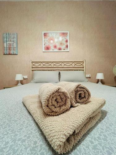 a bedroom with a large bed with towels on it at El Almazán in Buñol