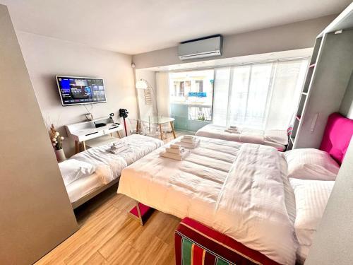 a small bedroom with two beds and a tv at Studio at the heart of Carre D'or 2 mins Sea Wi-fi in Nice
