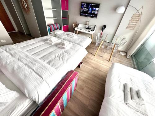 a room with two beds and a table and a tv at Studio at the heart of Carre D'or 2 mins Sea Wi-fi in Nice