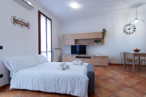 a bedroom with a bed and a kitchen with a table at Sole Luna Homes - Appartamenti in Corte in Cernusco sul Naviglio