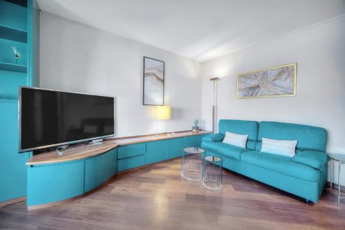 un salon avec un canapé bleu et une télévision à écran plat dans l'établissement Le Saint Louis - Parking - Central - Terrace - AC - Spacious, au Cannet