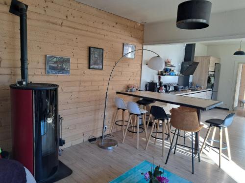 - un salon avec une cheminée, une table et des tabourets dans l'établissement Chez Laetitia, à Gérardmer