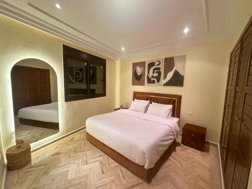 una camera da letto con un grande letto bianco e uno specchio di Exclusive Luxury Stay with Pool, Jacuzzi and Service a Marrakech