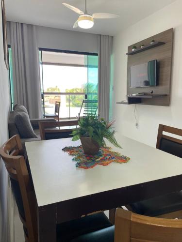 a dining room table with a potted plant on it at Varanda Gourmet Diversão Pet Praia do Francês in Praia do Frances