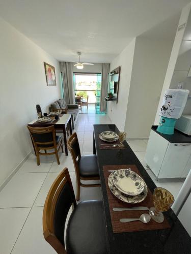 a kitchen and living room with a table and chairs at Varanda Gourmet Diversão Pet Praia do Francês in Praia do Frances