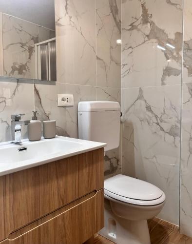 a bathroom with a white toilet and a sink at Emma's House in Agrigento