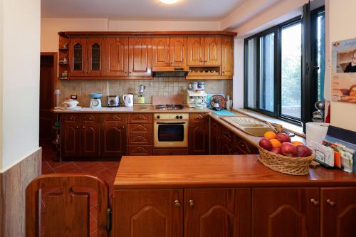 - une cuisine avec des placards en bois et un bol de fruits sur le comptoir dans l'établissement Casa la Pieve, à Berat