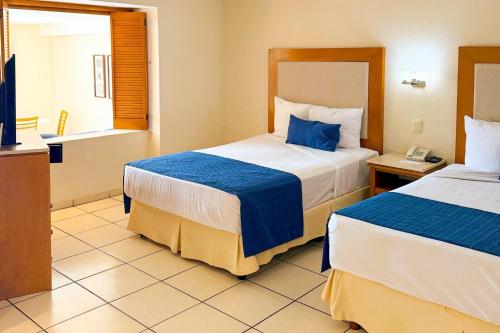 una habitación de hotel con dos camas y teléfono en Exclusive Beach Access & Amenities!, en Puerto Vallarta