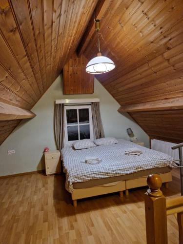 a bedroom with a bed and a wooden ceiling at De Bedstee in Schoondijke