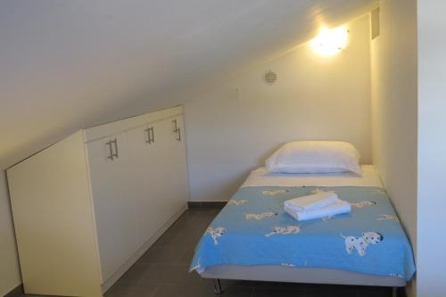 a small bedroom with a bed and a white cabinet at Apartments Maris in Maslenica