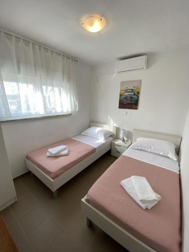a bedroom with two beds and a window at Apartments Maris in Maslenica