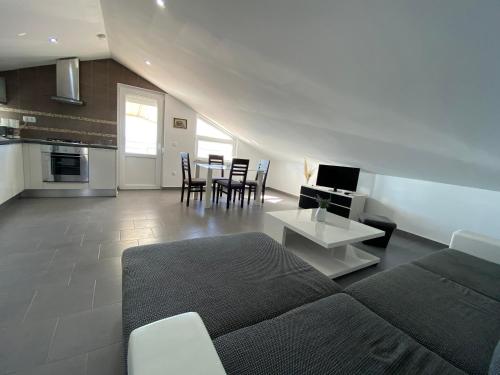 a living room with a couch and a table with chairs at Apartments Maris in Maslenica