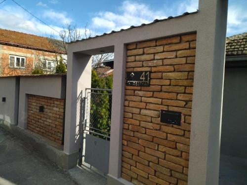 a door to a brick building with a sign on it at Konak Garavi sokak in Kuršumlija