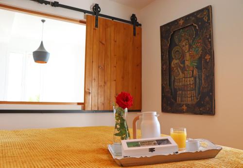 a table with a plate of food and orange juice at Casa das Rosas e Casa Do Mar in Arco da Calheta
