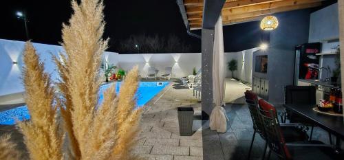 a patio with a swimming pool at night at Villa White Pearl Buna in Hodbina