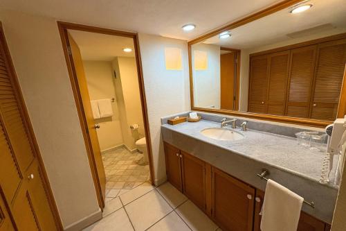 Un baño con lavabo y un espejo grande. en Partial View with bars and beach access!, en Puerto Vallarta