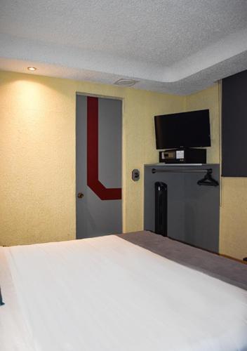 a hotel room with a large bed and a television at Frida Costa Azul in Mexico City