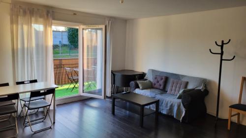 un salon avec un canapé et une table dans l'établissement B&B Sweet Meauxtown - Gare de Meaux, à Villenoy