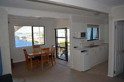 a kitchen and dining room with a table and chairs at Austria Motel in Paihia