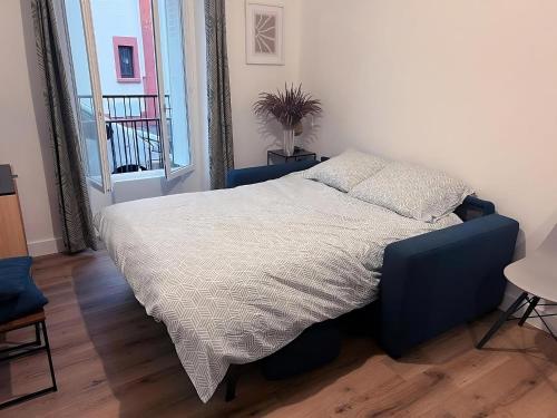 une chambre avec un lit avec une couette blanche dans l'établissement Cozy studio near Paris, à Maisons-Alfort