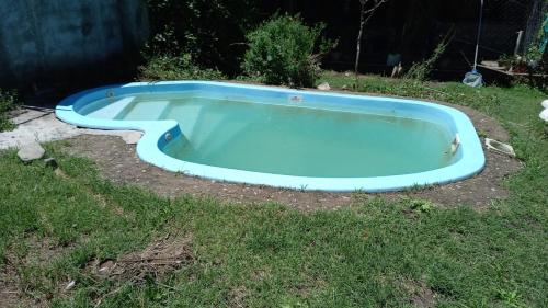una piscina azul en el césped en un patio en Cabaña giardino, en Villa Giardino