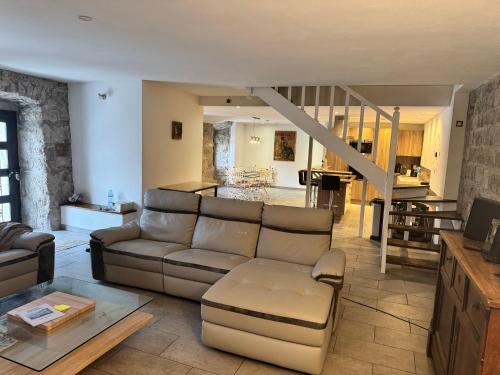 un salon avec un canapé et un escalier dans l'établissement Ardèche maison 12 personnes, à Usclades-et-Rieutord