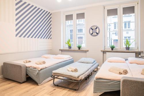 Habitación con 3 camas y ventanas. en Lily Apart - Private rooms in the Old Town, en Gdansk
