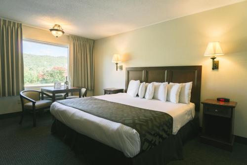 a hotel room with a large bed and a window at Town & Country Inn & Resort in Gorham