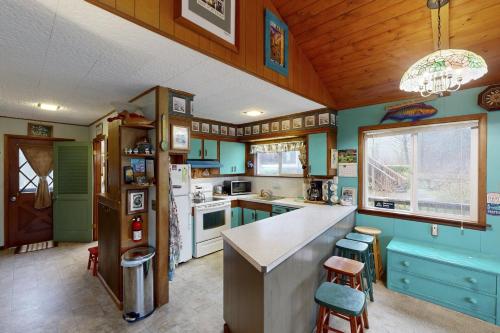 a kitchen with green walls and a counter and stools at Darrs Beach Cottage in Neskowin