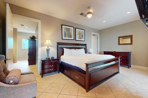 Un dormitorio grande con una cama y un sofá. en Sapphire Bungalow #106, en South Padre Island