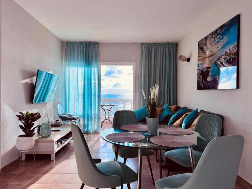 a living room with a table and chairs and a couch at Sunset apartment in Puerto de Santiago