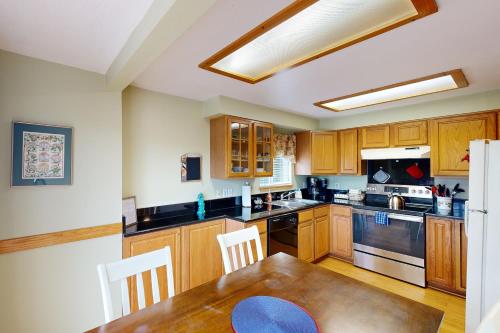 a kitchen with wooden cabinets and a wooden dining table at 2 Bed 1 Bath Vacation home in Seaside in Seaside