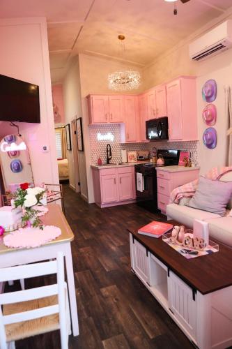 a kitchen with pink cabinets and a living room at Dolly's Place 6260 in Dover