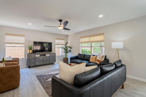 sala de estar con muebles de cuero negro y TV de pantalla plana en Dos Palmas Gilbert Poolside Retreat, en Gilbert