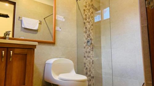 a bathroom with a toilet and a shower at Hotel PUENTE PIEDRA PARK in Villa de Leyva