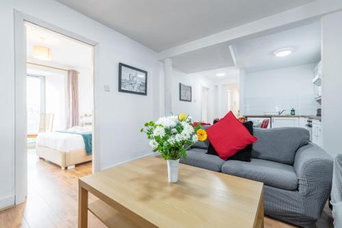 a living room with a couch and a table with flowers at Spacious 3-Bed Apt in Dublin Center in Dublin
