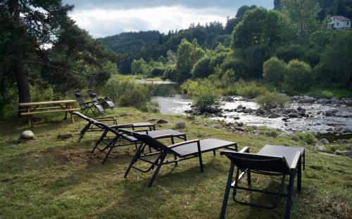 a group of chairs and tables next to a river at Maison en Ardeche in Usclades