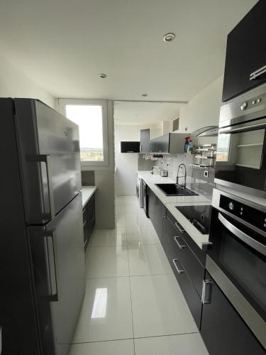 une grande cuisine avec des appareils en acier inoxydable et une fenêtre dans l'établissement Moderne appart 8 pers Marignane - aéroport - plage, à Marignane