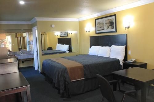 a hotel room with a bed and a bathroom at El Rancho Inn in Hawthorne