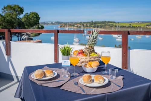 una tavola con piatti di cibo e bicchieri di vino di Ria Guest House ad Alvor