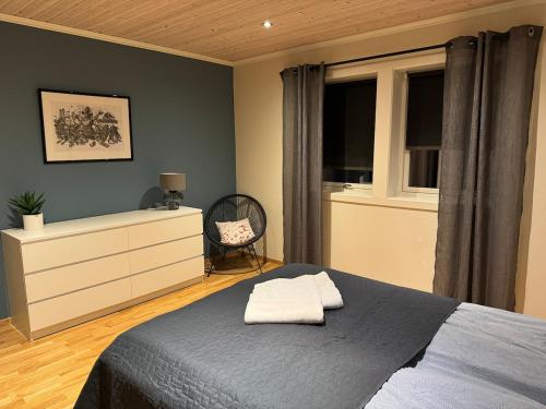 a bedroom with a bed and a dresser and a window at Villa Gratangen in Gratangen