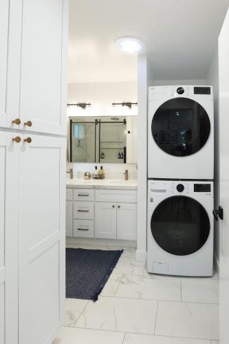 a white kitchen with a washing machine and a sink at Tranquil Mountain Retreat in Santa Cruz in Santa Cruz