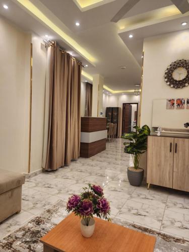 un vestíbulo con una sala de espera con flores en una mesa en Hana Stay Hostel, en Luxor