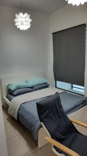 a bedroom with a bed and a chair and a chandelier at Spectacular Suite in the heart of Cyberjaya in Cyberjaya