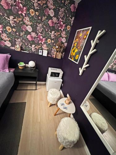 a small room with purple walls and flowers on the wall at Artists' Nest in Marsaskala