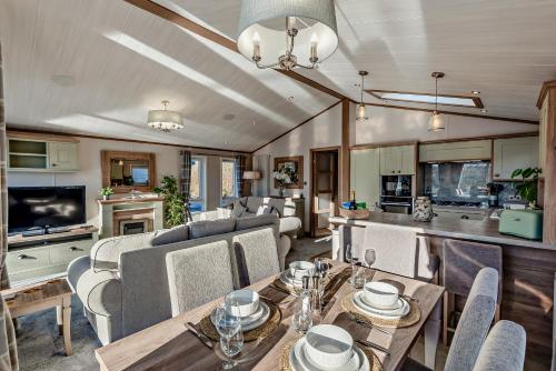 ein Wohnzimmer mit einem Tisch und einigen Stühlen in der Unterkunft Kingfisher Lodge - Lakeside Lodge With Hot Tub in Woodhall Spa