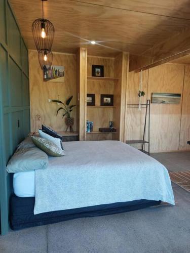 Un dormitorio con una cama grande en una habitación. en Hosts on the Coast Estuary Views Studio, en Whangamata