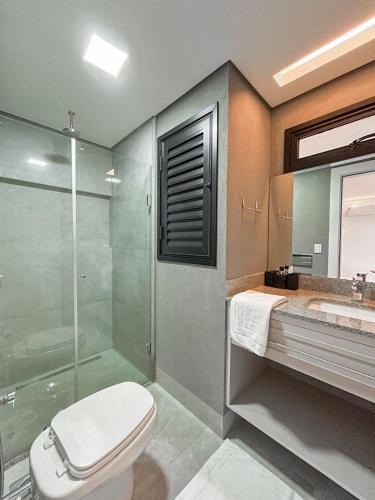 a bathroom with a shower and a toilet and a sink at Loft Confortável e Elegante com Quarto Fechado in Campo Grande