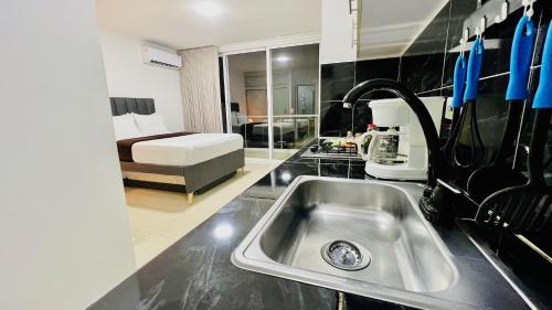 una cocina con fregadero y una cocina con cama en 402 studio apartment in El Peñon, en Cali